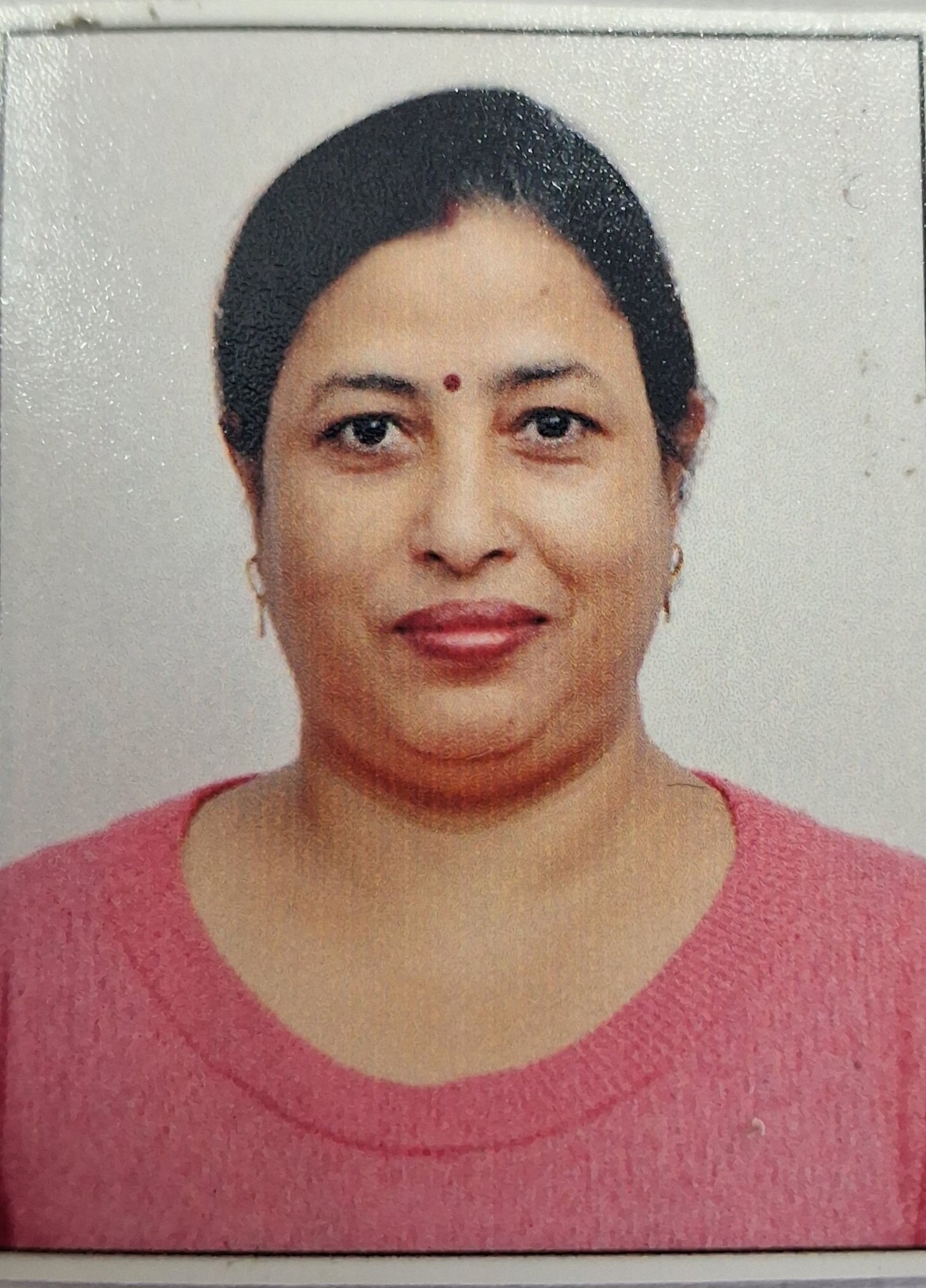 Portrait of Dr. Kapoor wearing traditional attire with academic books in background